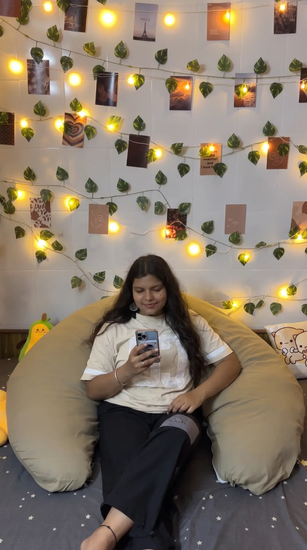 Woman using her phone while resting against the Diwan Body Pillow